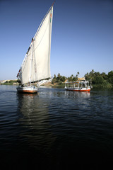 Obraz premium a sailboat and a motorboat in nile next luxor