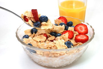 Breakfast cereal with strawberries, blueberries, orange juice