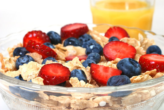Breakfast cereal with strawberries, blueberries, orange juice
