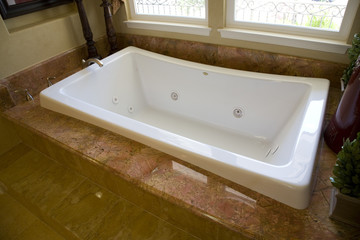 Spacious bathroom with a modern tub and tile floor.