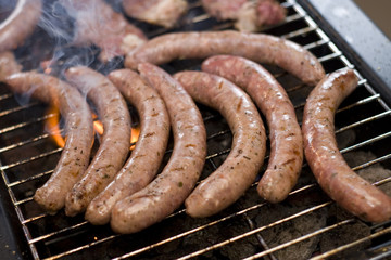 Barbecue sausage on grill with flame and smoke