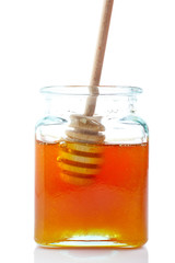 Drizzler inside of honey jar, reflected on white background.