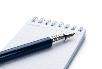 Pen on notebook, isolated on white background.