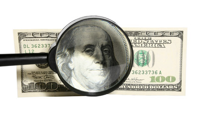 Magnifying glass and 100 dollars isolated on white background