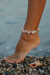 woman's foot with the sea shell bracelet