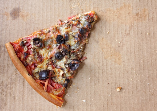 Last lonely slice of pizza, in pizza box.  