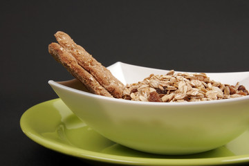 Cereals on white plate against a black background