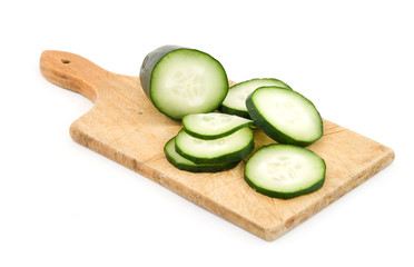 sliced cucumber on wooden plank isolated