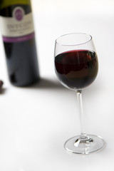 red wine in a glas, bottle on background