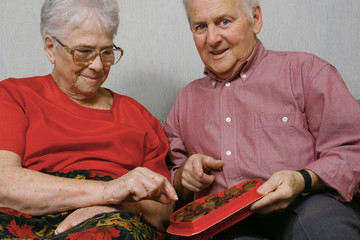 Senior couple eating chocolates