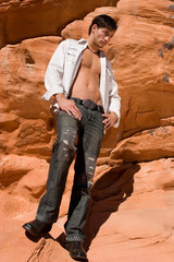 Sexy young man on red rocks