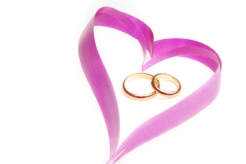 Close-up photo of the ribbon heart with wedding rings