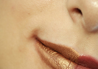 Macro image of bright lips. Red and gold lipstik