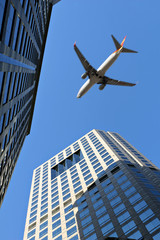 Fototapeta na wymiar Samolot lądowania leci nad budynków (samolot z motion blur)