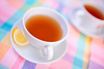 A view of a cups of tea and a slice of lemon
