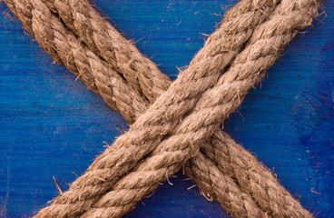 Rope in "X" letter formation, tied to a blue wooden surface
