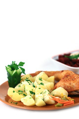 close up of a roasted chicken with potatoes arranged in a plate