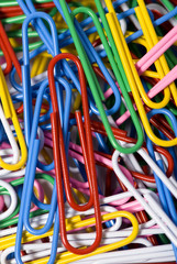 A close up of colorful paperclips in an office