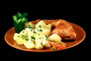 close up of a roasted chicken with potatoes arranged in a plate