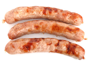 three fried chipolata sausages on a white background