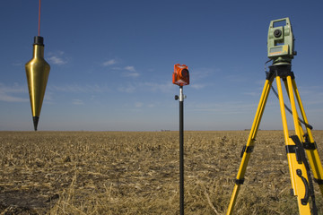 Total station, prism and plumb-bob in the field.