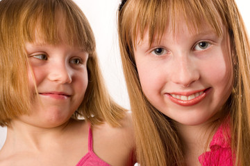 Two beautiful little smiling girls isolated on white background