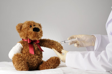 a teddy bear with an amputated claw getting an injection