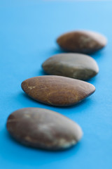 Fototapeta na wymiar Spa stones lined up on the blue background