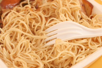 plastic fork digging  takeout noodles (shallow depth of field)