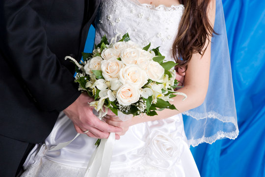 white rose bouquet in the hands of the bride and the groom