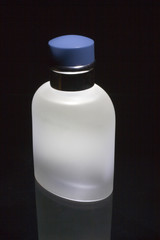 a white bottle of cologne on a black background