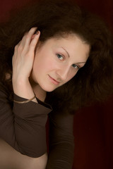 Portrait of the young smiling woman on a dark background.