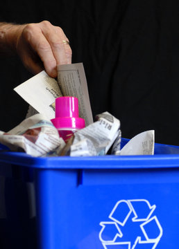hand putting recycling in bin with plastic and paper