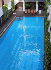 Indoor blue swimming pool. Girl inside.