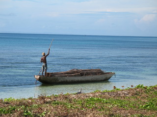 piroguier en bord de plage transportant des materiaux
