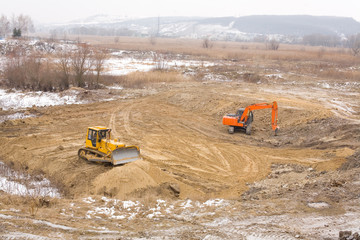 Excavator and bulldozer prepare platform before construction