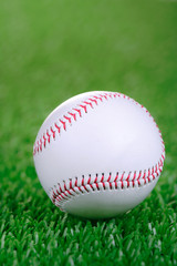 Baseball ball against green grass background