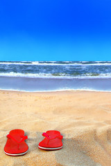  Rote Badeschuhe am Strand