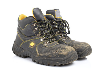 A pair of old work boots with soft shadow on white background