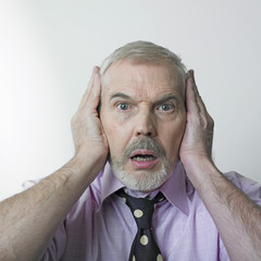 Surprised man covering ears