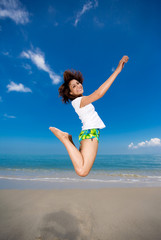 young beautiful girl jumping happily at the beach