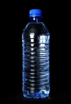 Bottled water with droplets over a black background