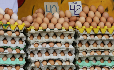 A giant pile of brown eggs for sale in an outdoor marketplace