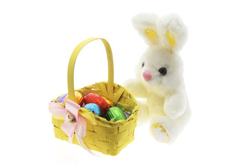 Easter Eggs in Basket with Easter Toy Bunny on White Background