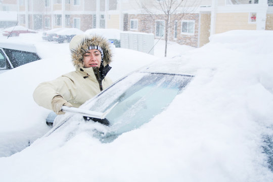 Woman Scraping Snow Off Of Windshield