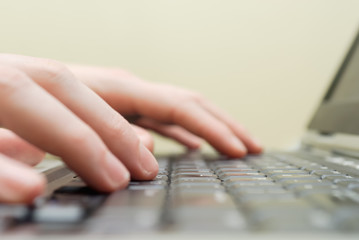 Extreme closeup of hands typing with laptop