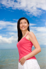 woman smiling looking far with red top & white skirt 