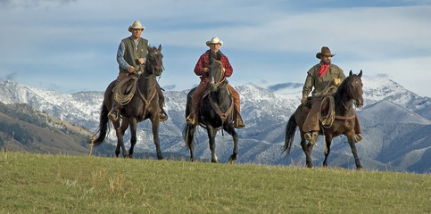 Cowboys riding the range, mountain background. Montana