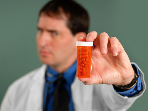 Doctor showing bottle of pills, shallow DOF.