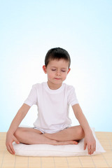 6 years old boy relaxing on blue background